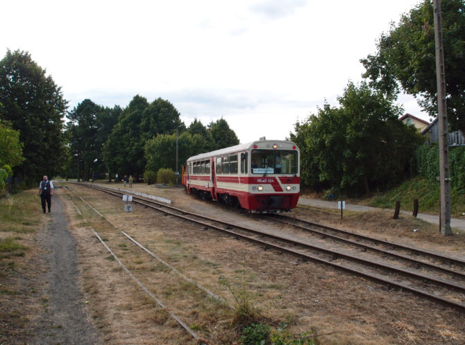 Vlak tažený historickým úzkorozchodným motorovým vozem MBxd2 odjížděje ze stanice Stegna se blíží k výhybce, kde se napojí na trať souběžnou s pobřežím.